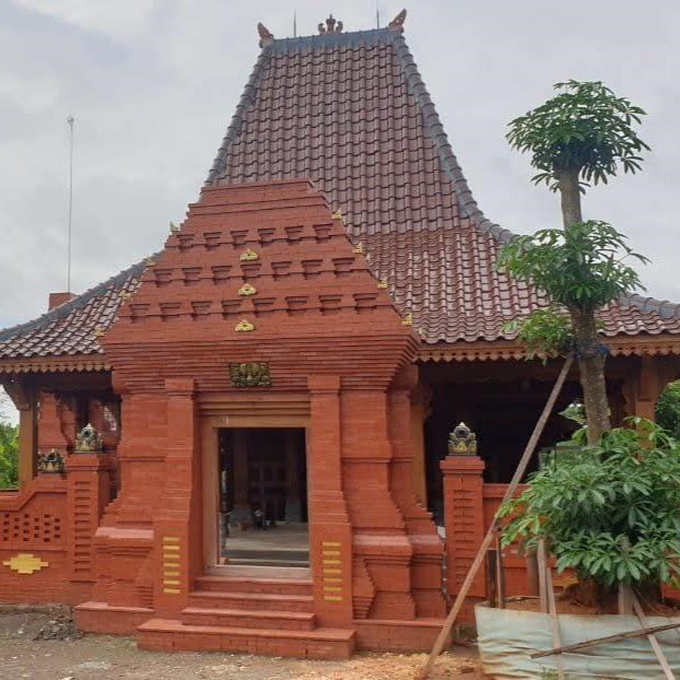 Rumah Jawa dengan atap joglo, detail kayu dan ukiran tradisional yang mempesona.